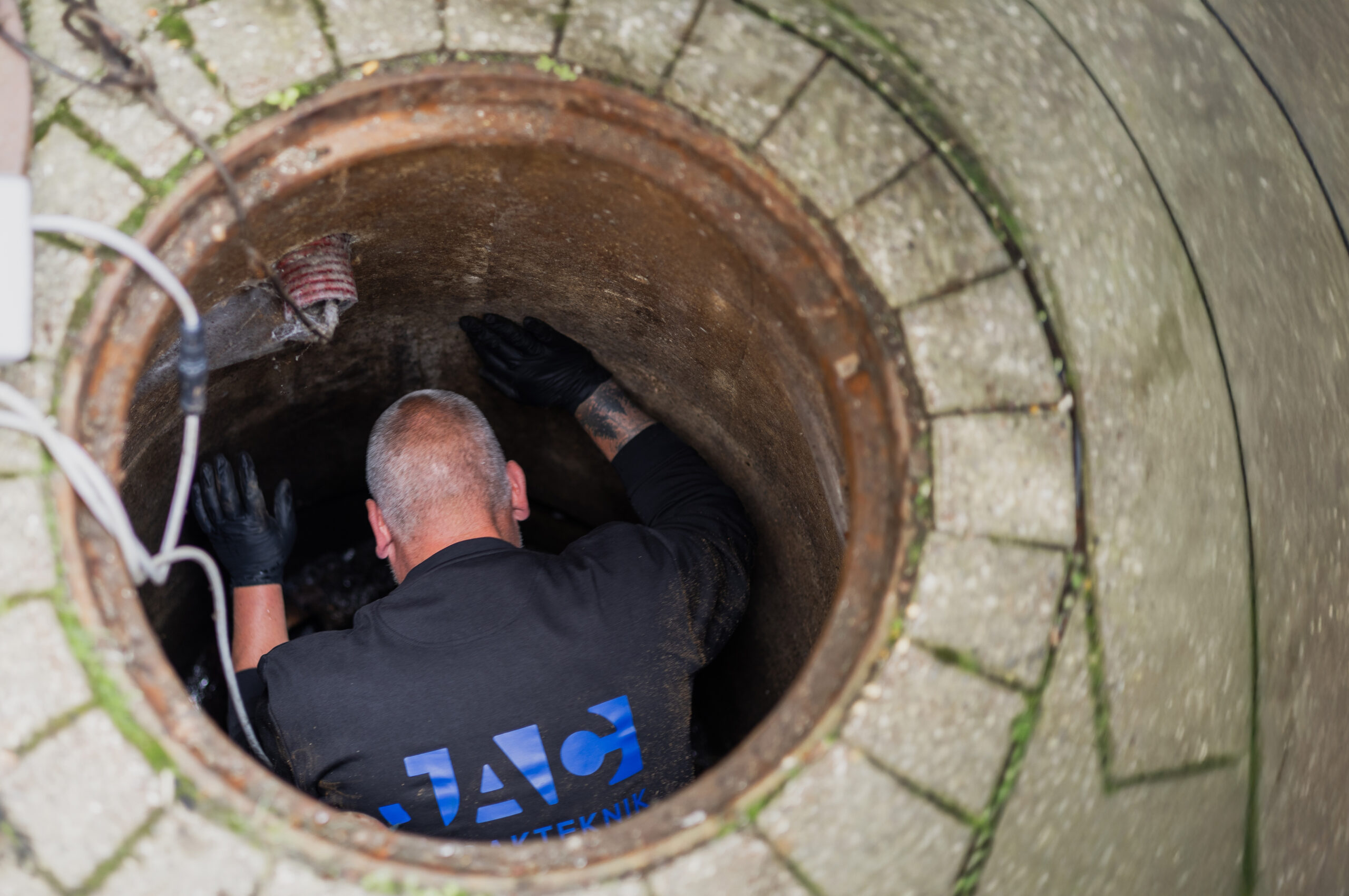 Person arbejder i brønd med installation eller inspektion af rottespærre.